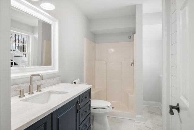 bathroom with marble finish floor, toilet, a stall shower, vanity, and baseboards