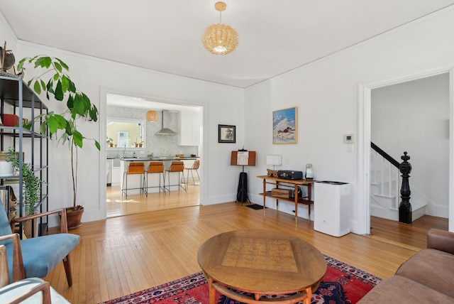 living room with hardwood / wood-style floors, stairway, and baseboards