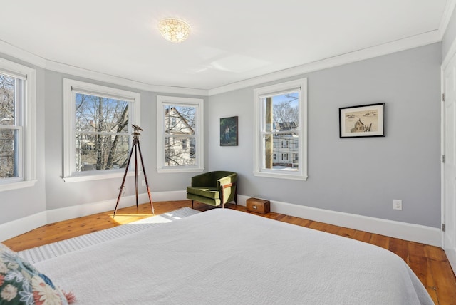 bedroom with crown molding and wood finished floors