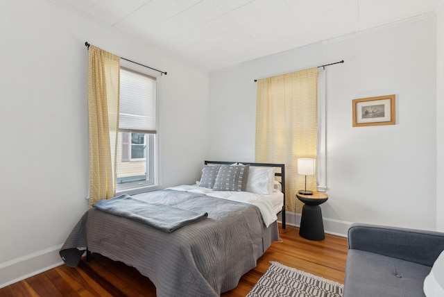 bedroom with wood finished floors and baseboards