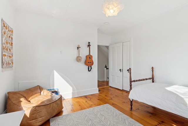 bedroom featuring light wood-style flooring, baseboards, and a closet