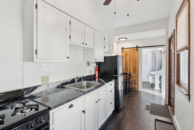 kitchen with visible vents, a sink, black range with gas stovetop, white cabinetry, and a barn door