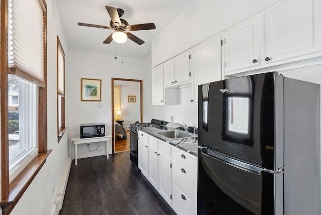 kitchen with black appliances, a sink, dark wood finished floors, white cabinetry, and baseboard heating