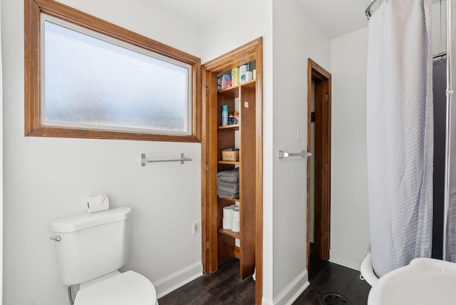 full bathroom with curtained shower, baseboards, toilet, and wood finished floors