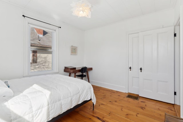 bedroom featuring hardwood / wood-style floors, baseboards, and visible vents