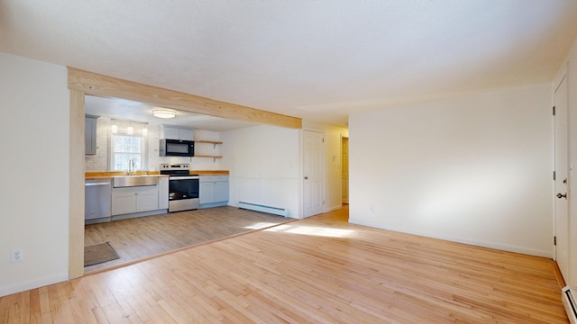 kitchen with baseboard heating, appliances with stainless steel finishes, wooden counters, and light hardwood / wood-style flooring