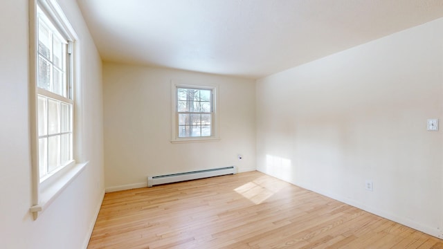 unfurnished room with a baseboard radiator and light hardwood / wood-style floors