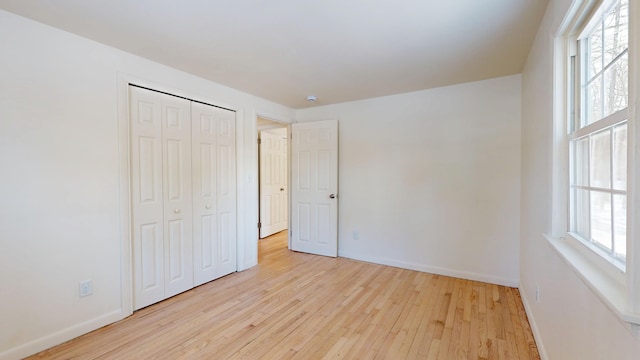 unfurnished bedroom featuring light hardwood / wood-style flooring and a closet