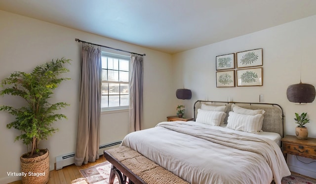 bedroom with a baseboard radiator and light wood-type flooring