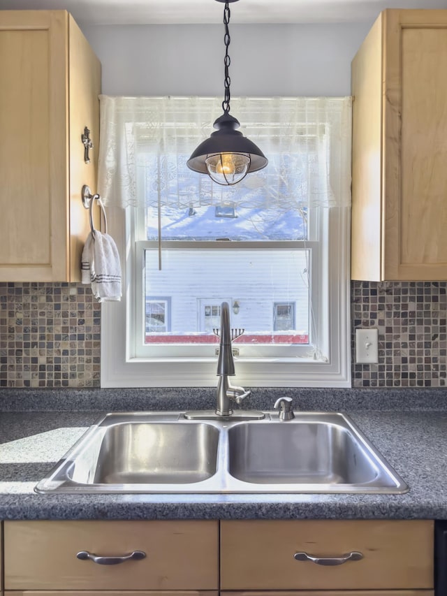 details with decorative backsplash, dark countertops, light brown cabinets, and a sink