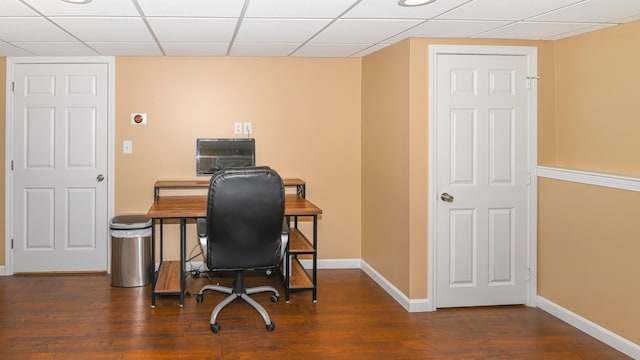 office featuring dark wood-type flooring, a drop ceiling, and baseboards