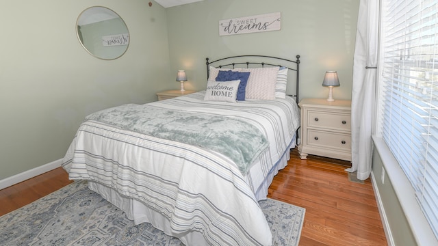 bedroom with baseboards and wood finished floors