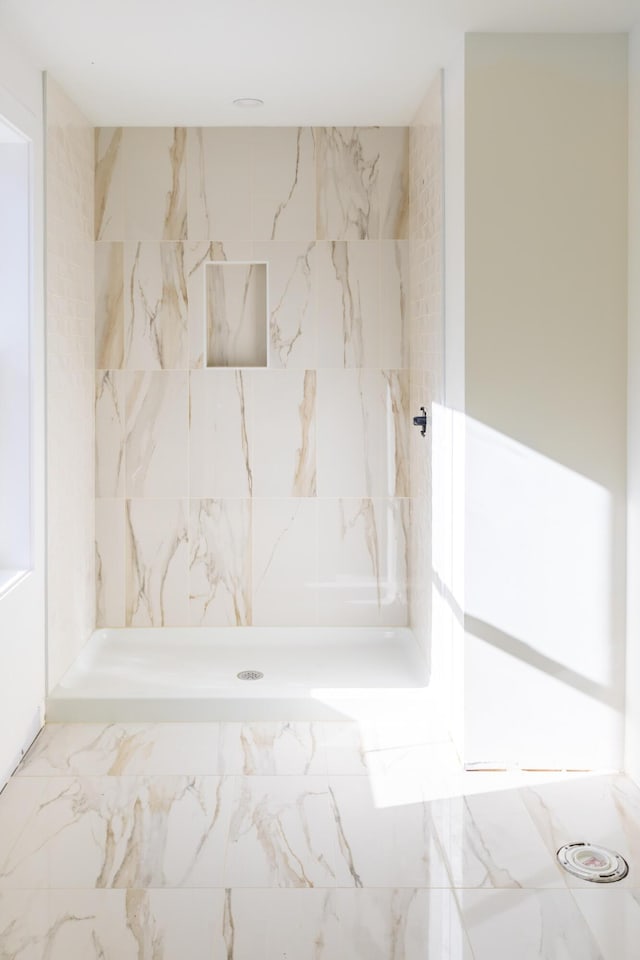 full bath featuring marble finish floor and a shower stall