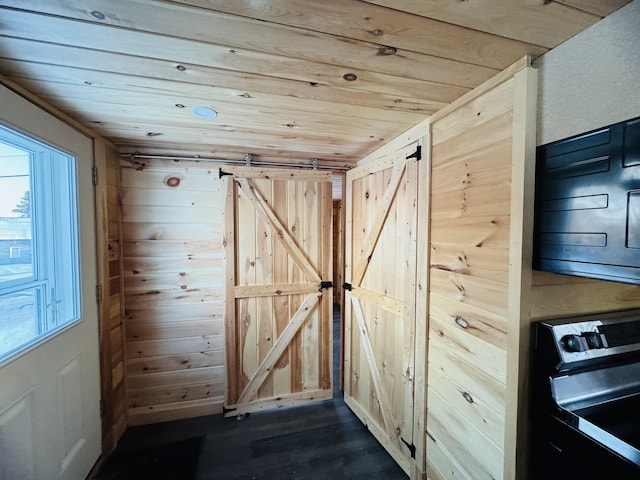 interior space with wood ceiling, wooden walls, and a barn door