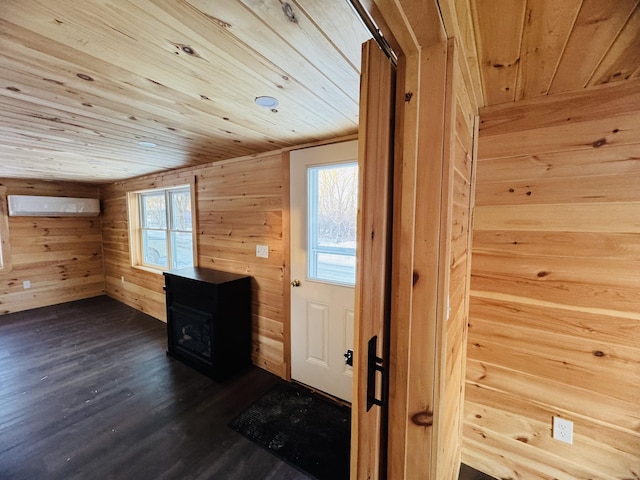 interior space with wood ceiling, plenty of natural light, a wall mounted AC, and wood walls