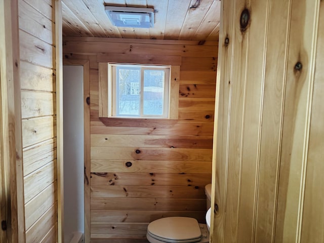 bathroom featuring wooden ceiling, wooden walls, and toilet