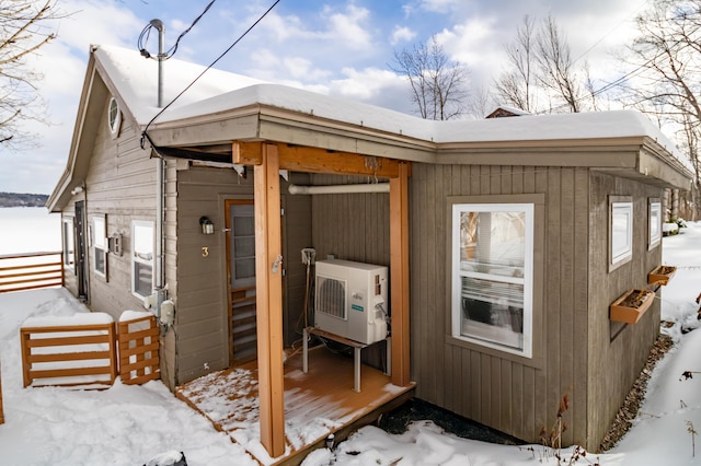 snow covered structure with ac unit