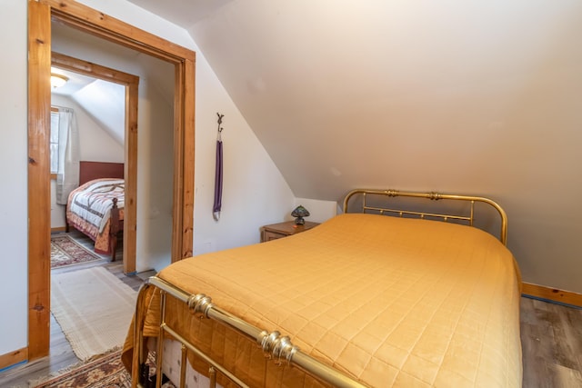 bedroom featuring hardwood / wood-style flooring and lofted ceiling