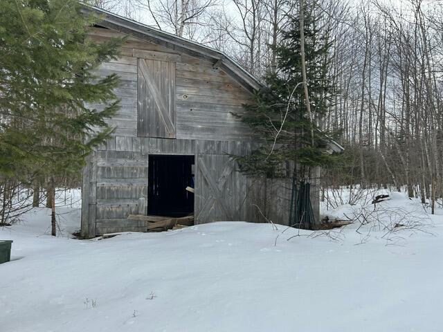 view of snow covered exterior with a barn and an outdoor structure