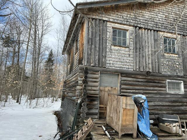 view of snowy exterior with log siding