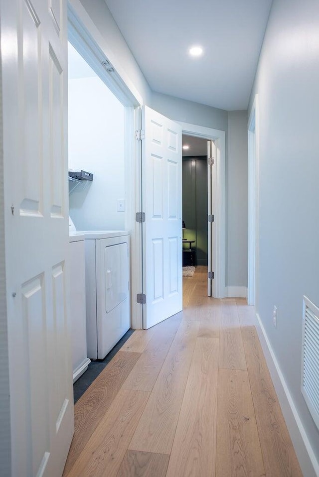 hallway featuring washing machine and dryer and light wood-type flooring