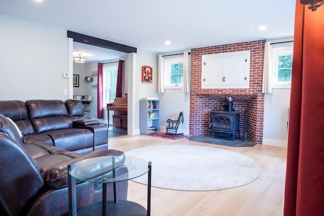 living room featuring a wood stove and light wood-type flooring