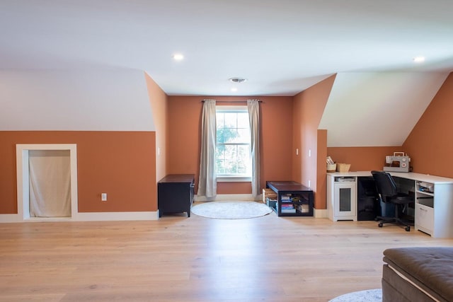 living room featuring lofted ceiling and light hardwood / wood-style flooring