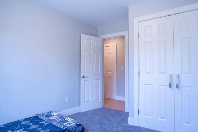 unfurnished bedroom featuring dark carpet and a closet