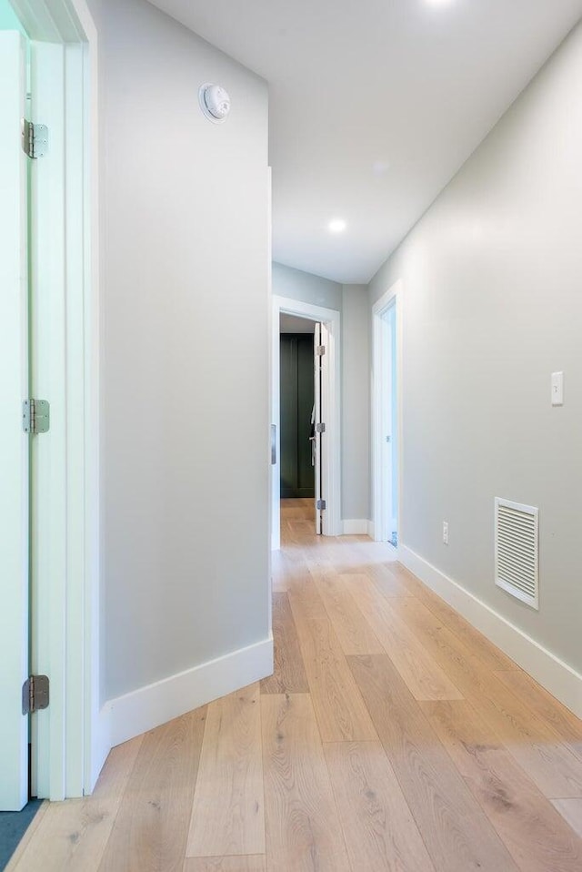 hallway with light hardwood / wood-style floors