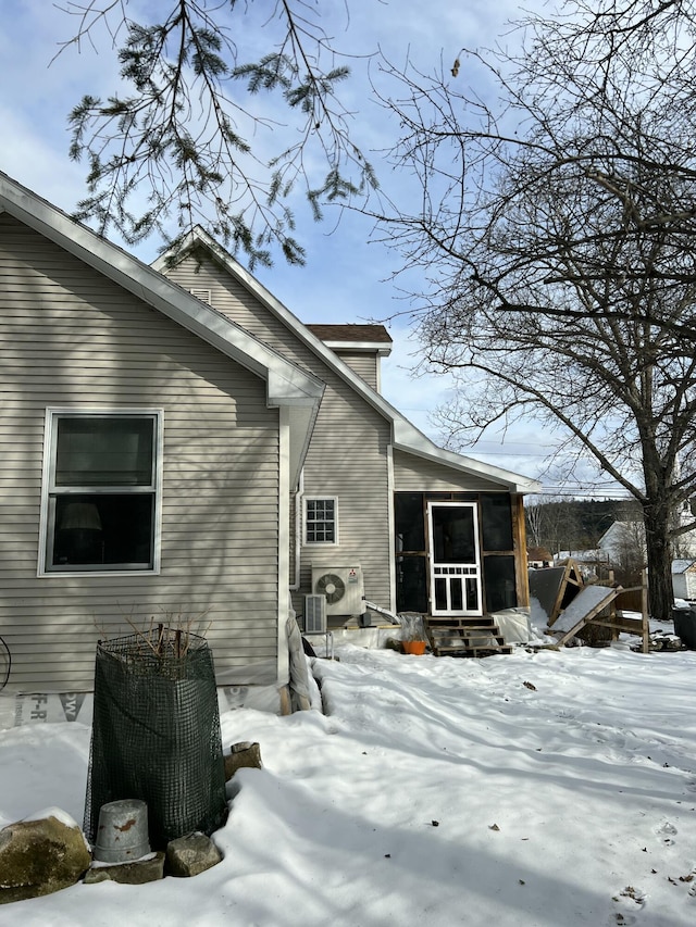 view of snow covered exterior with a sunroom