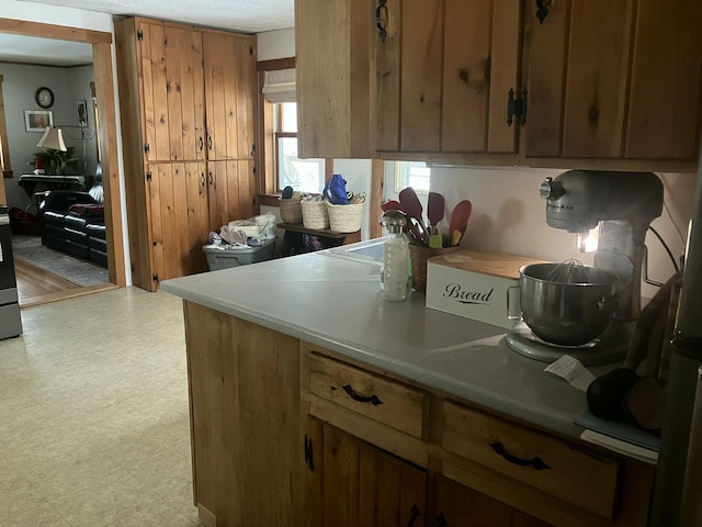 kitchen featuring light floors, light countertops, and brown cabinets