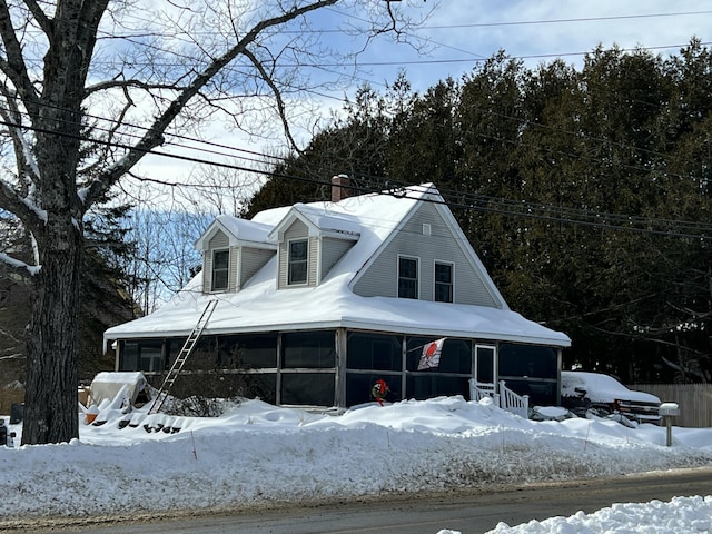 view of front of home featuring a chimney and a sunroom