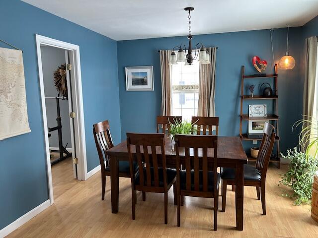 dining area with an inviting chandelier and light hardwood / wood-style floors