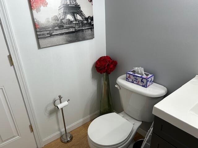 bathroom with vanity, toilet, and hardwood / wood-style floors