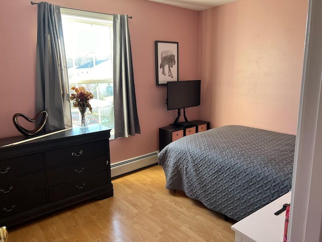 bedroom with light wood-type flooring and baseboard heating