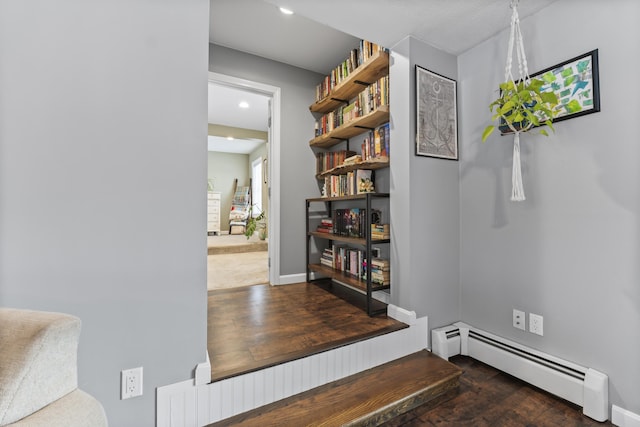 hallway featuring dark wood-type flooring and baseboard heating