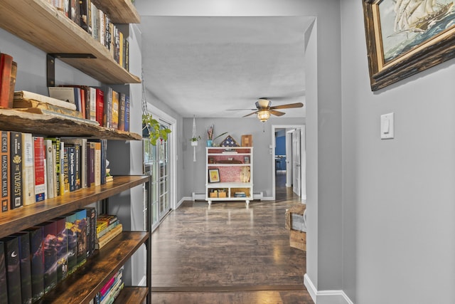 hallway featuring a baseboard heating unit and dark wood-type flooring