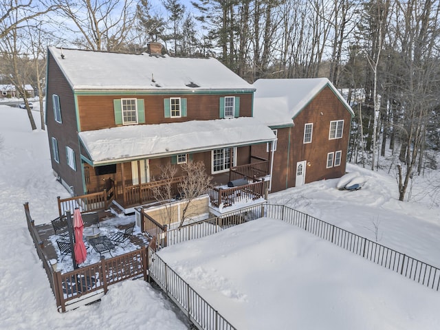 snow covered property featuring covered porch