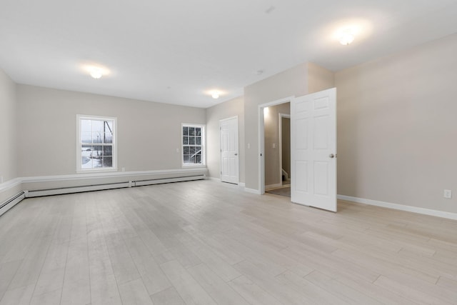 unfurnished room featuring light wood-type flooring and baseboard heating