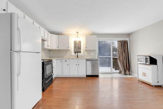 kitchen featuring pendant lighting, white cabinetry, sink, stainless steel appliances, and light hardwood / wood-style flooring