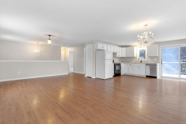 unfurnished living room featuring dark wood-type flooring, sink, and a notable chandelier