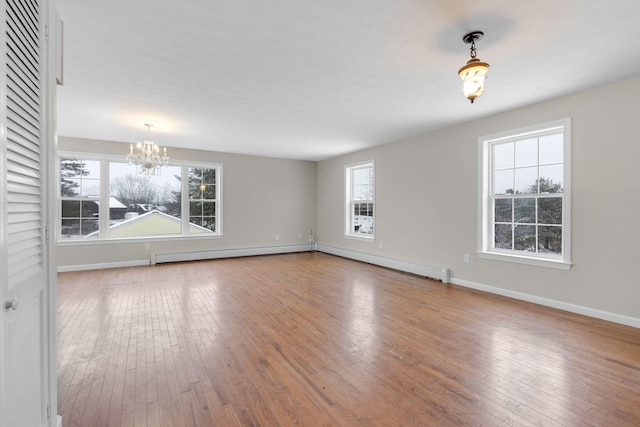 spare room with hardwood / wood-style flooring and a chandelier