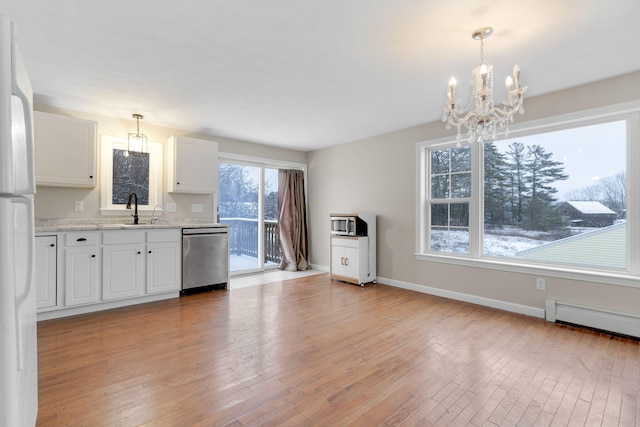 kitchen with sink, light hardwood / wood-style flooring, stainless steel dishwasher, pendant lighting, and white cabinets