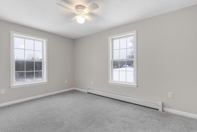 carpeted spare room featuring a baseboard radiator and ceiling fan