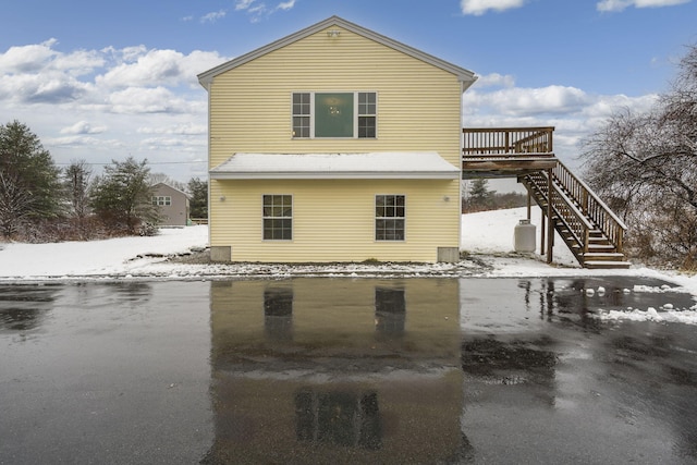 snow covered house with a wooden deck