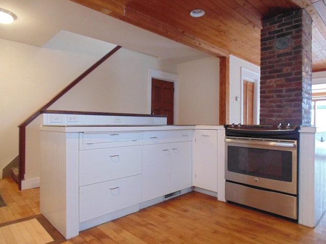 kitchen featuring light wood finished floors, wood ceiling, light countertops, stainless steel range with electric stovetop, and white cabinetry