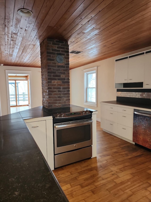 kitchen featuring appliances with stainless steel finishes, light wood-type flooring, a healthy amount of sunlight, and white cabinetry