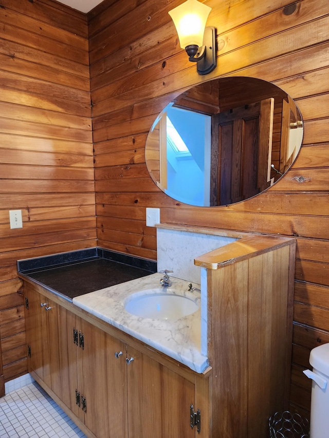 half bathroom with toilet, tile patterned flooring, and vanity