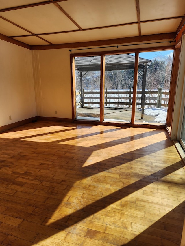 empty room with baseboards and wood finished floors