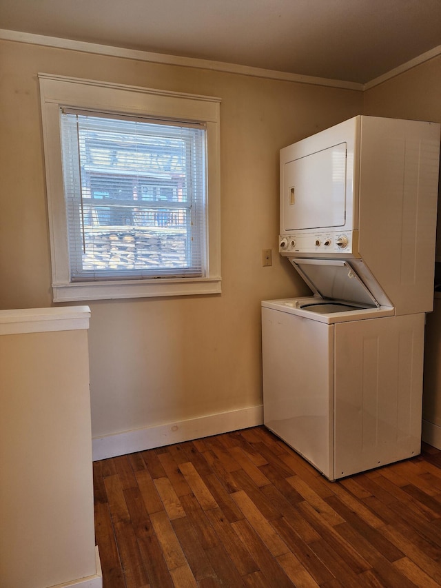 laundry area with dark wood-style flooring, stacked washer / dryer, and baseboards